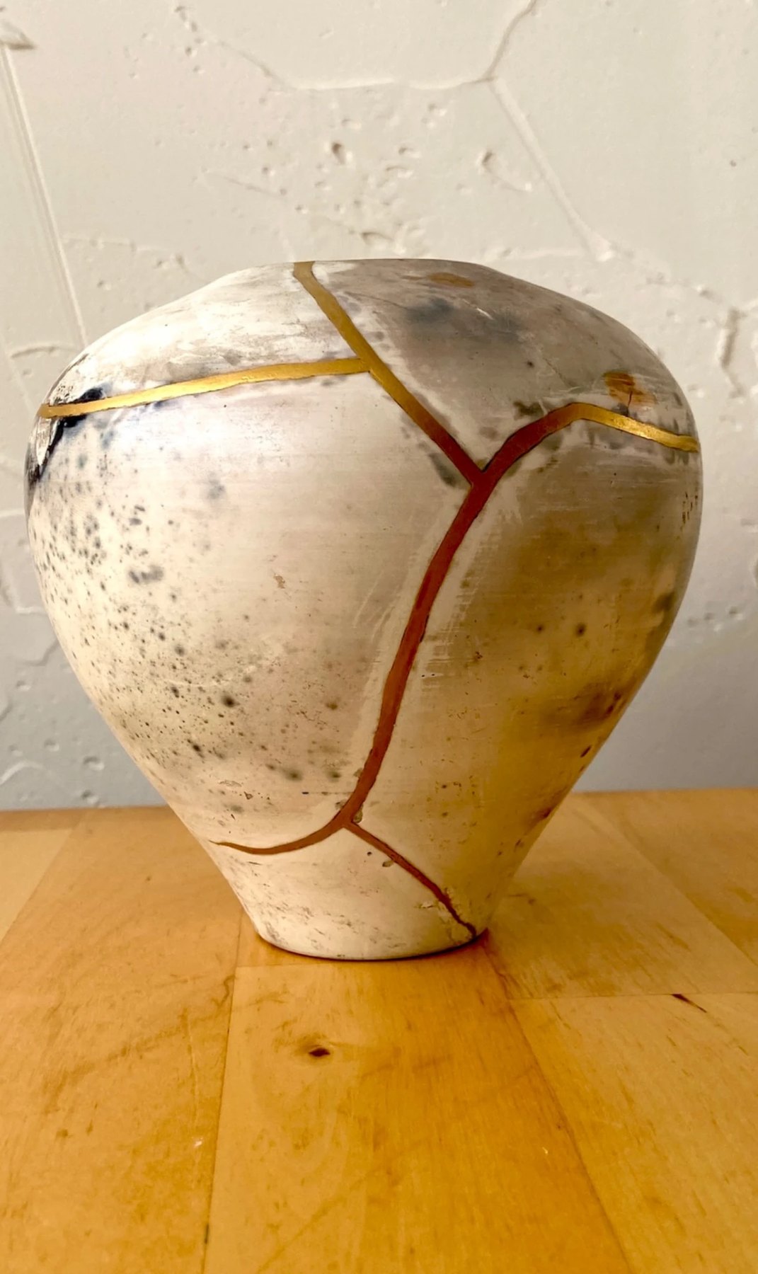 Hand-built vessel repaired with gold and red Kintsugi seams